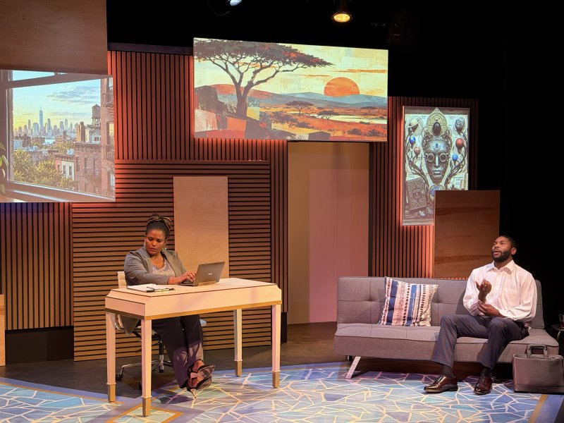 Two actors on a stage with three screens: a cityscape, an African landscape, and a mystical portrait.